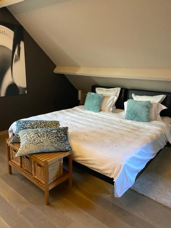 a bedroom with a large bed with blue pillows at Cosy Studio met Zwembad in Beringen