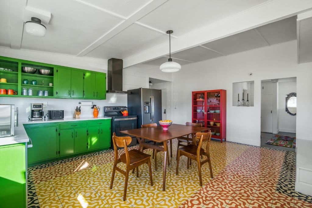 a kitchen with green cabinets and a wooden table and chairs at Wonder Valley Green House - Near Joshua Tree National Park in Twentynine Palms