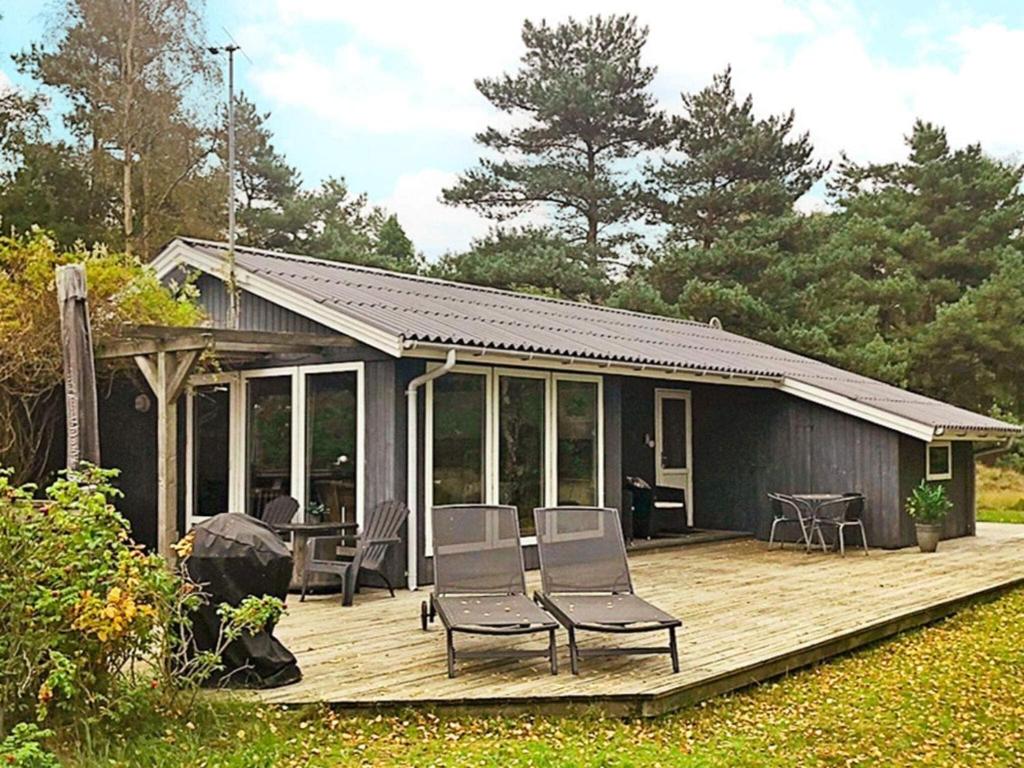 a house with chairs on a wooden deck at Holiday home Aakirkeby XLIV in Vester Sømarken
