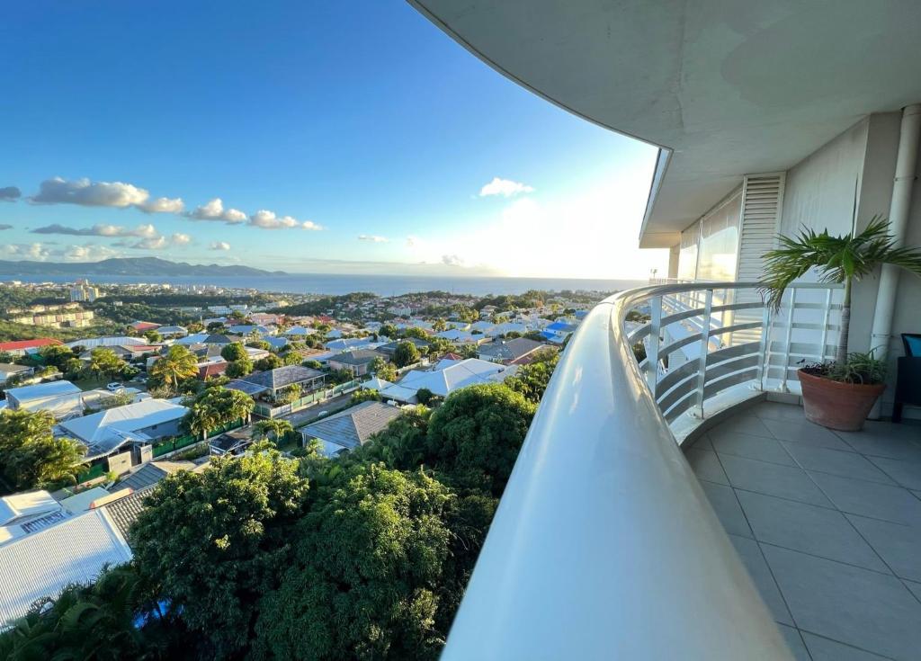 an apartment balcony with a view of a city at Appartement de standing vue mer in Schœlcher