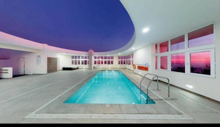una gran piscina en un edificio con techo púrpura en Edmundo Eluchans plaza 2066 Reñaca en Viña del Mar