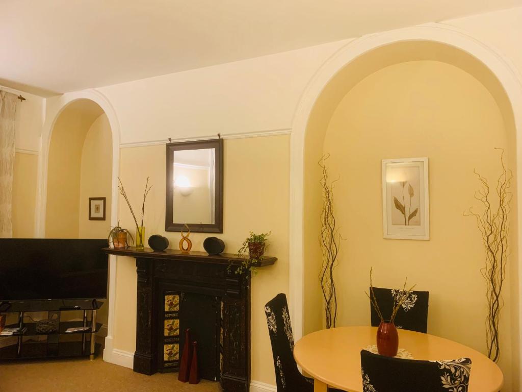 a living room with a table and a fireplace at 22A Cosy double bed town centre in Wellingborough
