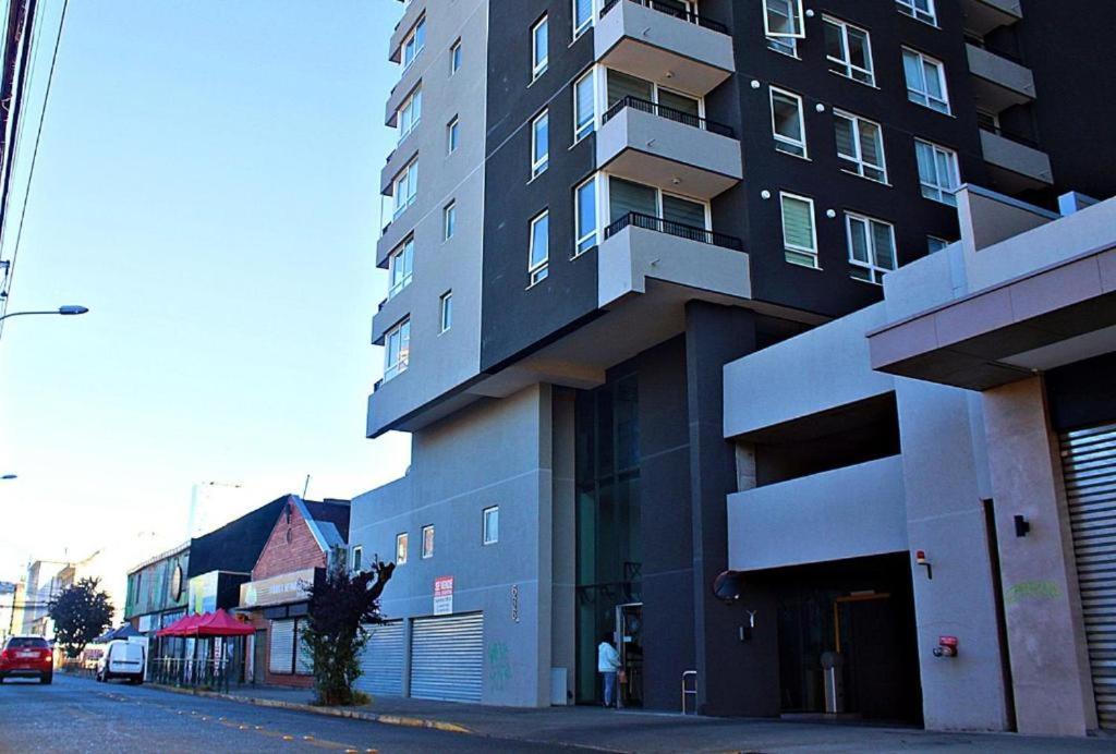 a tall building on the side of a street at Apart Hotel Bauerle & Apartamentos in Temuco