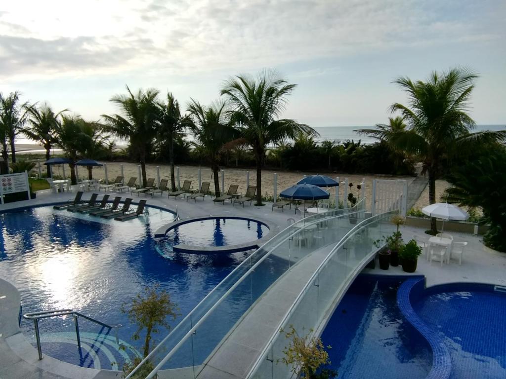 um resort com duas piscinas e palmeiras em Kaakupe Praia Hotel em Guaratuba