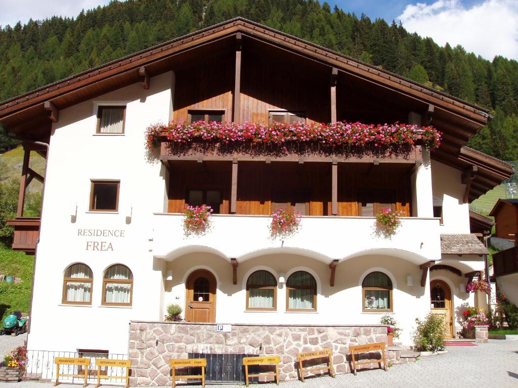 ein großes weißes Gebäude mit Blumen darauf in der Unterkunft Residence Frea in Wolkenstein in Gröden