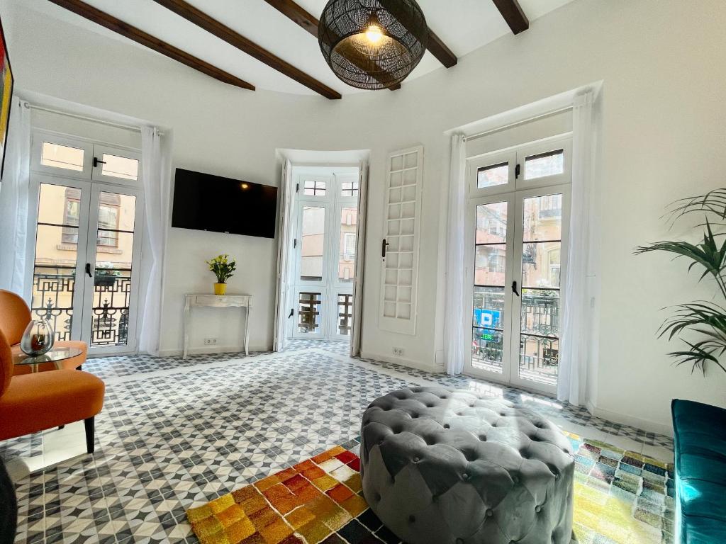 uma sala de estar com paredes brancas e janelas grandes em Puerta Roja 3 bedroom Luxury Apartment em Málaga