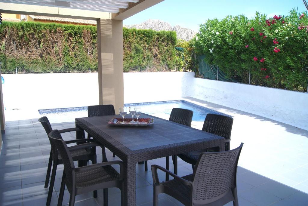 a table and chairs on a patio with a pool at Pomera III - BTB in Beniarbeig