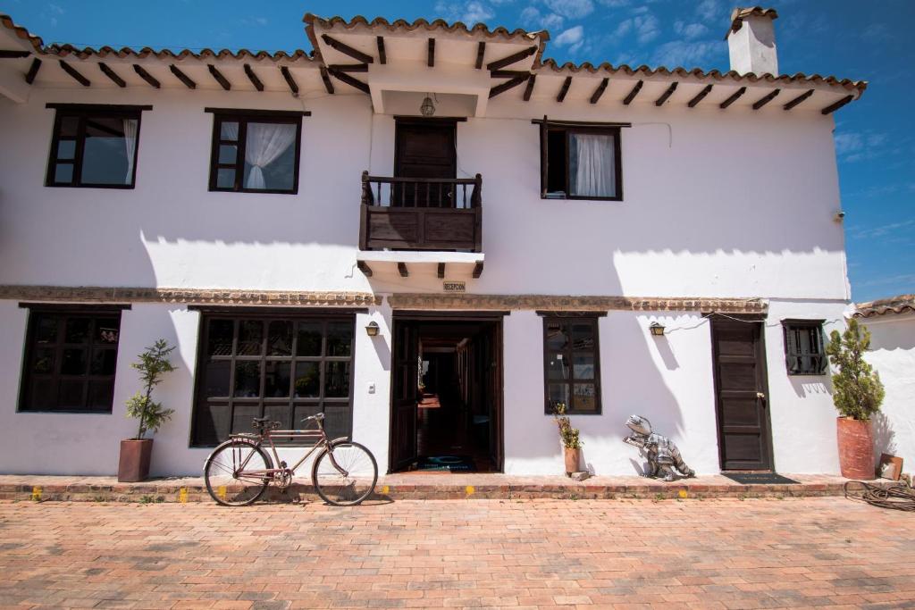 una bicicleta estacionada frente a una casa blanca en Hotel Villa Luna, en Villa de Leyva