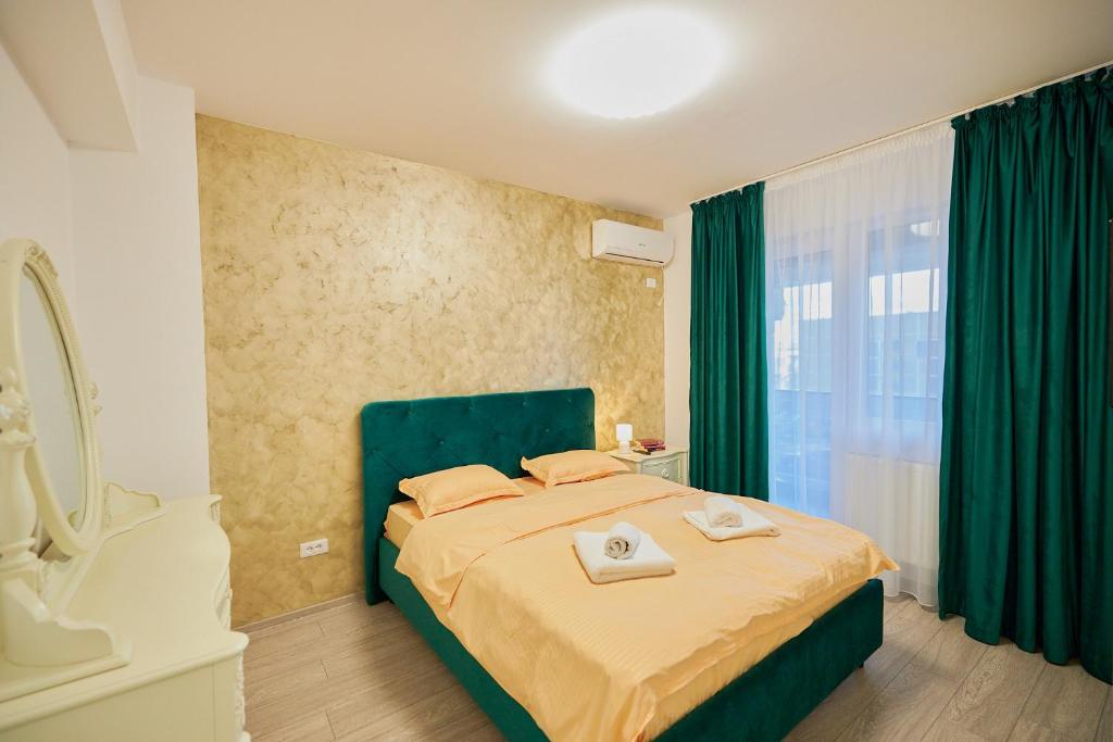 a bedroom with a bed with a green headboard and a window at CozyCollection Apartments at Q Residence #6 in Iaşi