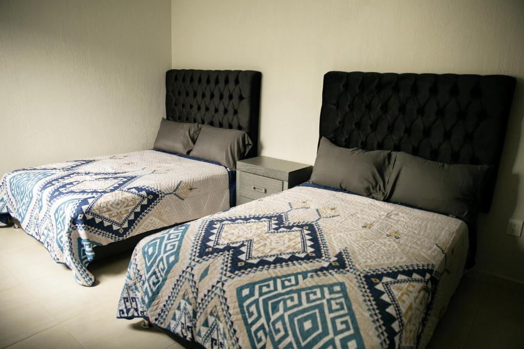 sypialnia z 2 łóżkami i zagłówkiem w obiekcie TORRE CARRANZA w mieście Tequila