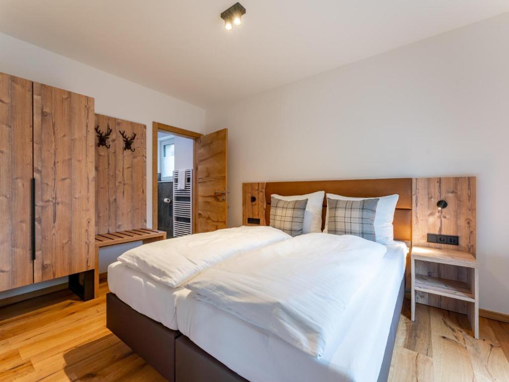 1 dormitorio con 1 cama blanca grande y paredes de madera en Mountain Chalet Alpinchique 2, en Sankt Lorenzen ob Murau