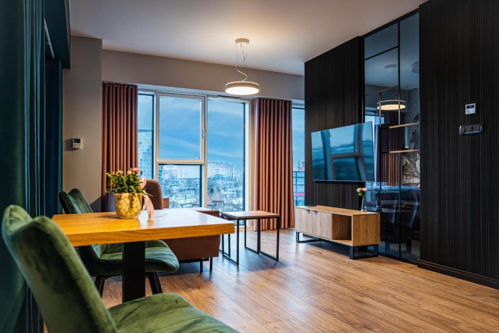 a living room with a dining table and a view of the city at Fillhus Apartments in Poznań