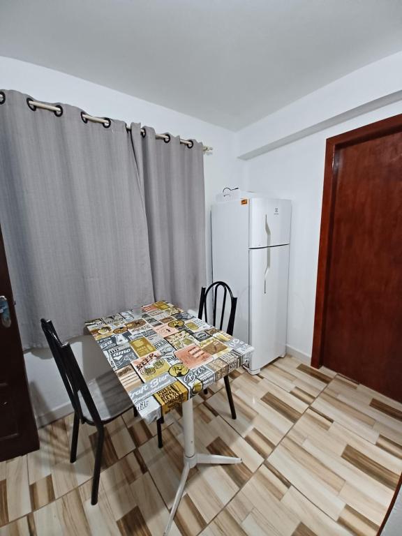 a dining room with a table and a refrigerator at Pequeno apartamento em chacara próximo às praias com internet in São Francisco do Sul