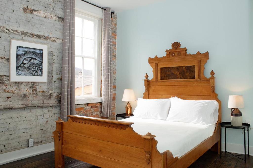 a bedroom with a large bed with a wooden headboard at Bischoff Inn - Former 1870 Furniture Factory Now 5 Room Boutique Hotel 
