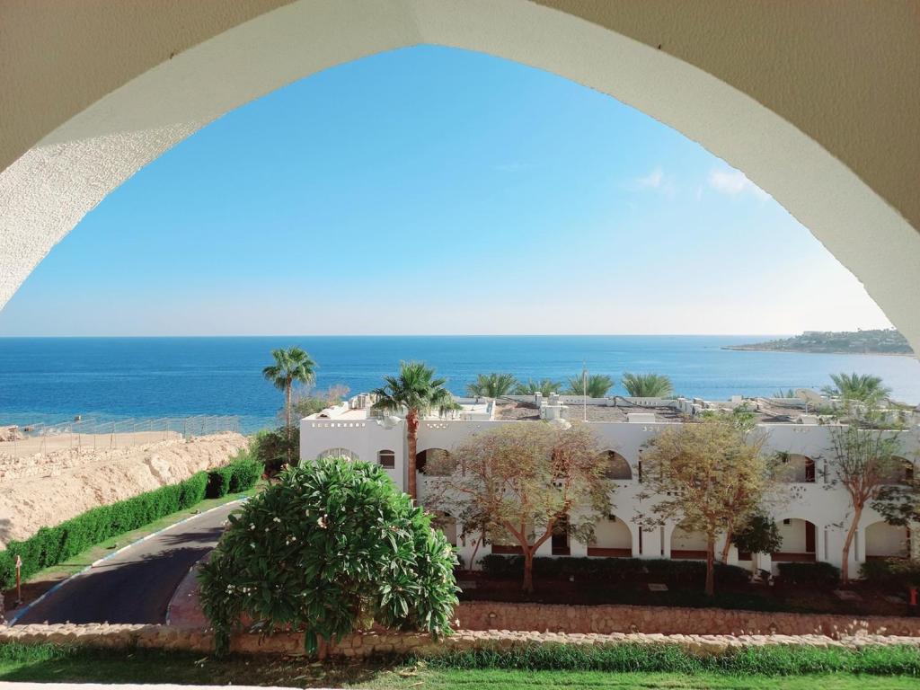 una vista de un edificio con el océano en el fondo en Domina coral bay Sultan - private room, en Sharm El Sheikh