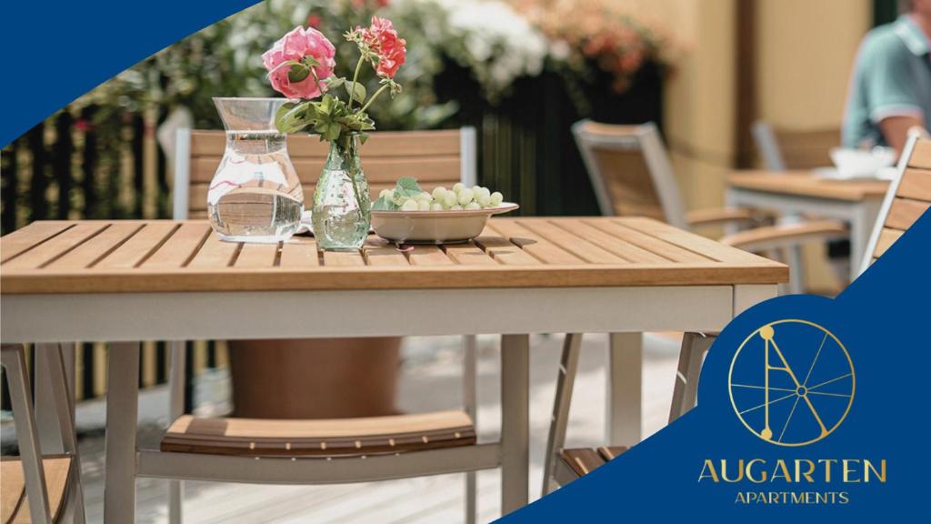 Una mesa de madera con un jarrón de flores encima. en Augarten Apartments, en Viena