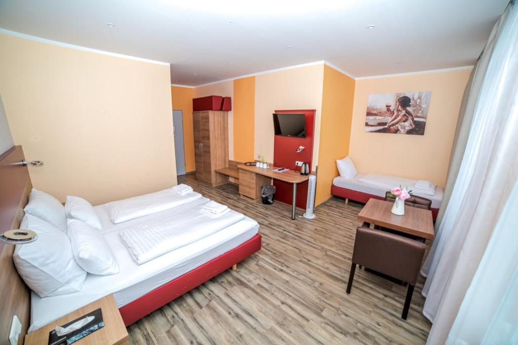 una camera d'albergo con letto e scrivania di Alexander Business Hotel Hannover City ad Hannover