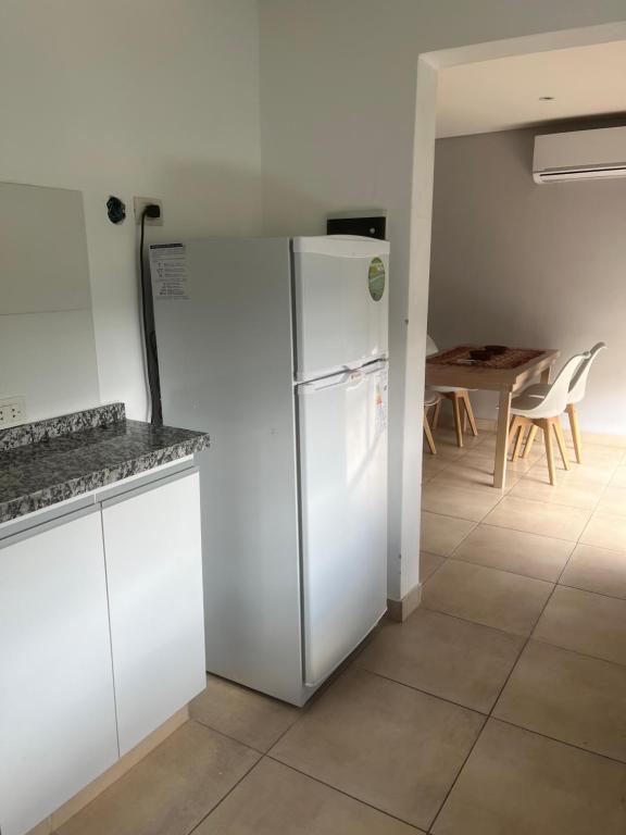 una nevera blanca en una cocina con mesa en New Apartment Talampaya en La Rioja