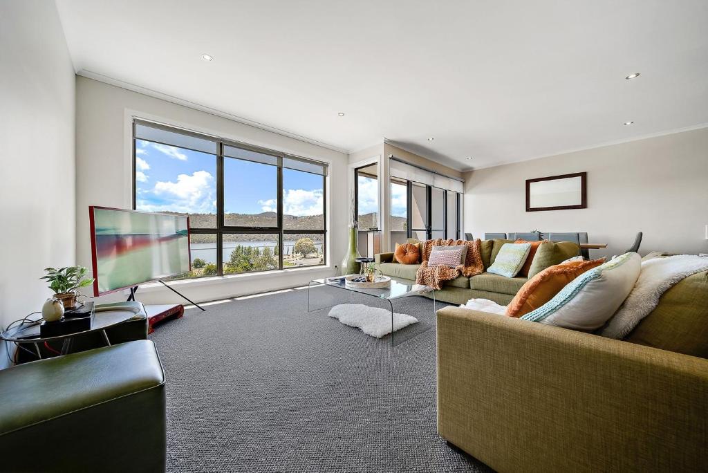 a living room with a couch and a television at Jasper 4 in Jindabyne