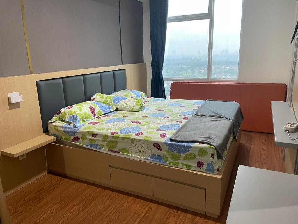 Cama pequeña en habitación de hospital con ventana en Luxury Apartemen Grand Lagoon Sungkono Surabaya, en Dukuhpakis