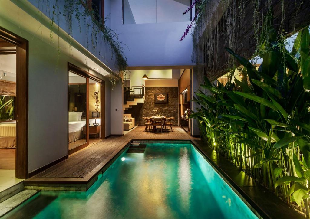 a swimming pool in the middle of a house at Agranusa Signature Villa Nusa Dua in Nusa Dua