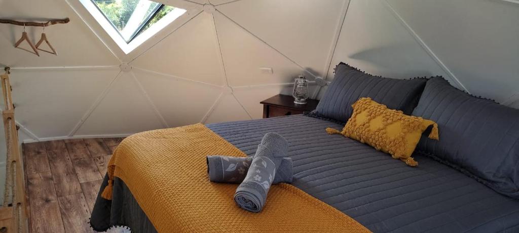 1 dormitorio con cama azul y manta amarilla en Domotel Aysen, en Puerto Aysén