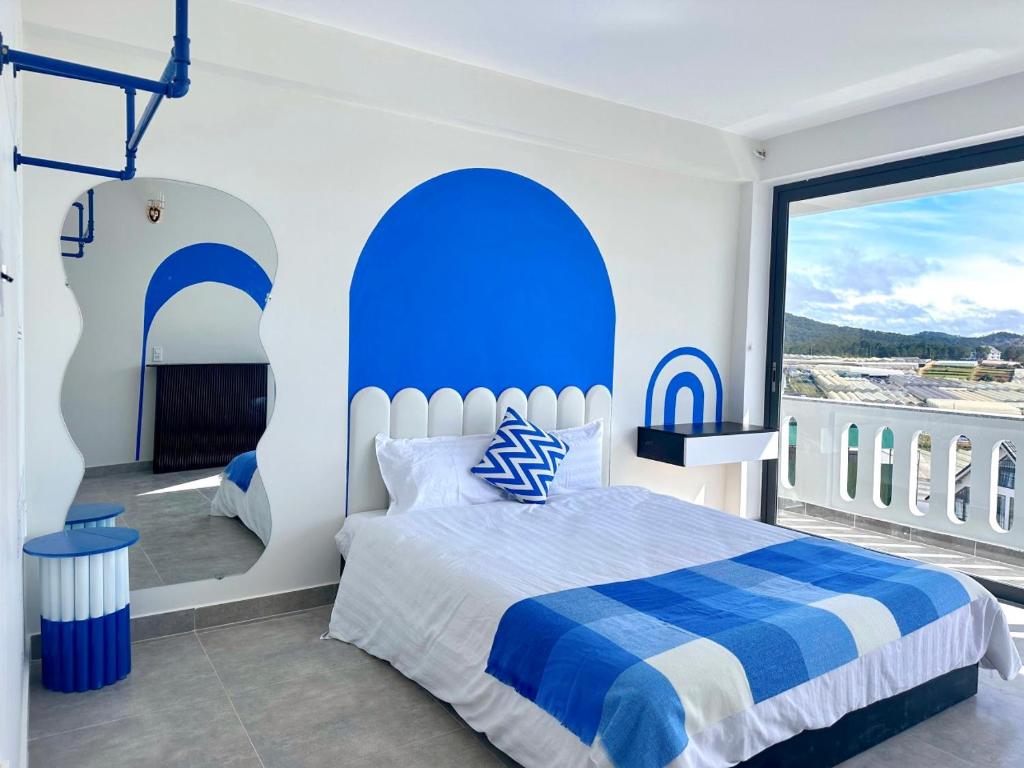 a bedroom with a blue and white bed and a window at Bear Brick Villa in Da Lat