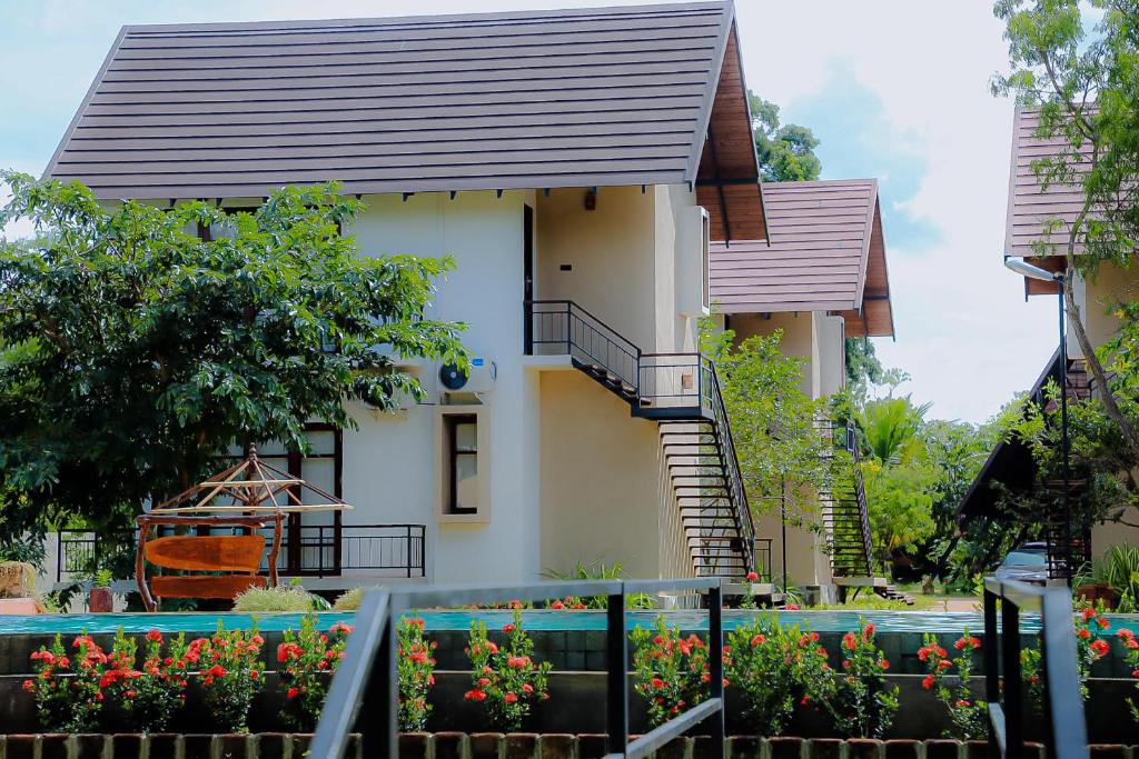 una pequeña casa con flores delante en Lolu Village Resort en Anuradhapura