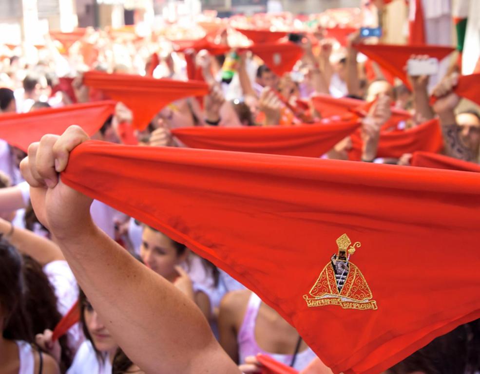 un gruppo di persone che sventolano bandiera rossa di HABITACIÓN VISTAS - Casa particular a Pamplona
