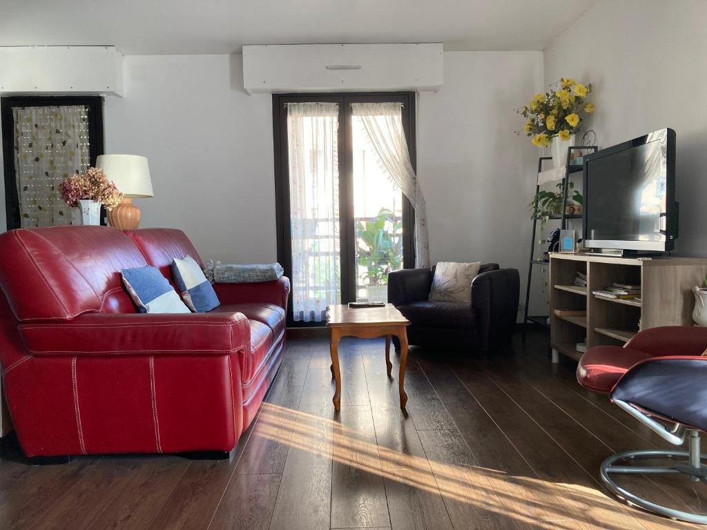 un salon avec un canapé rouge et une télévision dans l'établissement T3 - 62m2 - parking privé - métro, à Toulouse