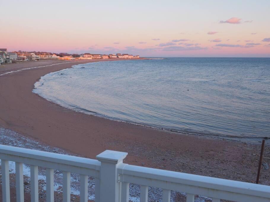 a beach with a white fence and the ocean at Casa al Mare Beachfront Retreat King Bed Near Yale in East Haven