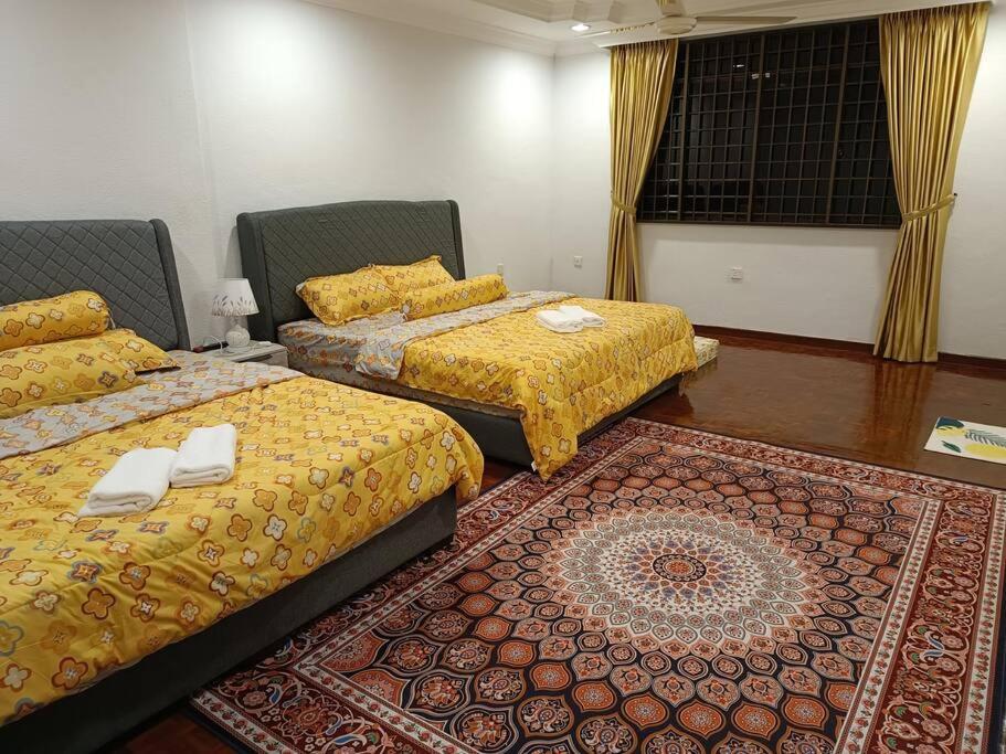 three beds in a room with a rug at Cosy and family friendly house in Sungai Petani