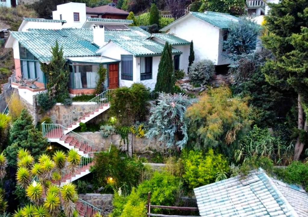 ラパスにあるApartamento de lujo con jardines paisajísticosの木立の丘の上の家