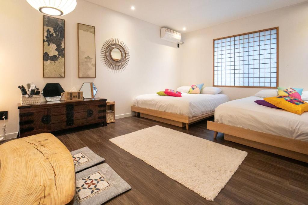 a bedroom with two beds and a window at Bias K-girl Guesthouse - Women only in Seoul