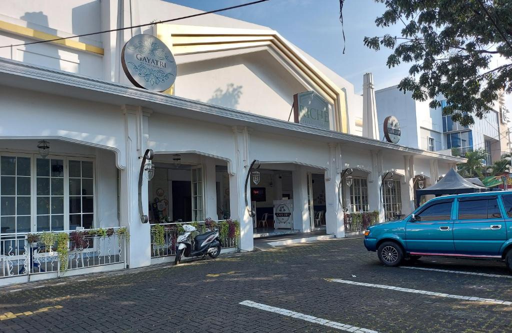 ein blaues Auto, das vor einem Gebäude parkt in der Unterkunft Riche Heritage Hotel in Malang