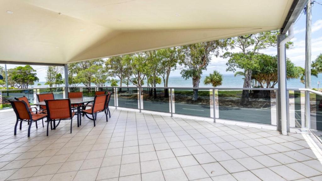a porch with a table and chairs and a view of the water at Magical holiday home - Welsby Pde, Bongaree in Bongaree