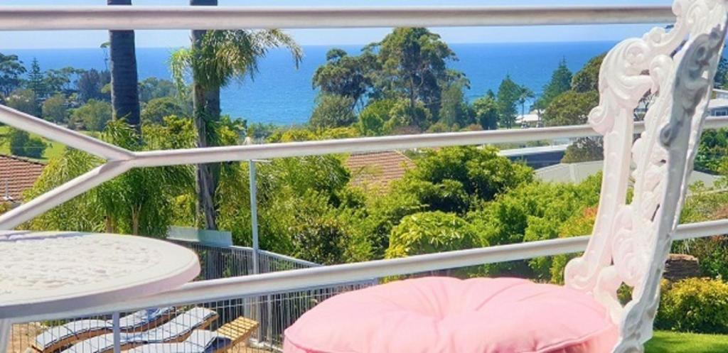 balkon ze stołem i krzesłami oraz oceanem w obiekcie Mollymook Ocean View Motel Rewards Longer Stays -over 18s Only w mieście Mollymook