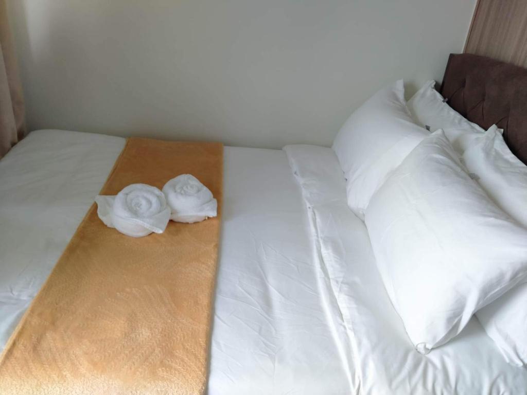 Cozy619 1BR at Shore 2 Tower 2 في مانيلا: سرير ابيض عليه منشفتين بيضاء