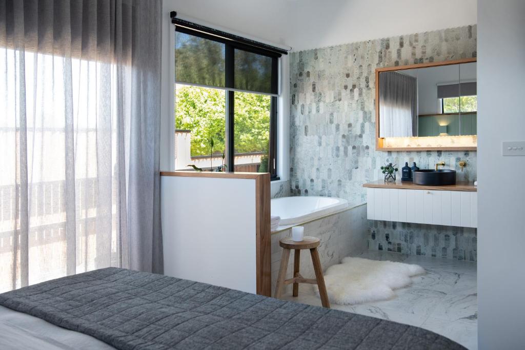 a bedroom with a bed and a tub and a mirror at Little Jem in Daylesford