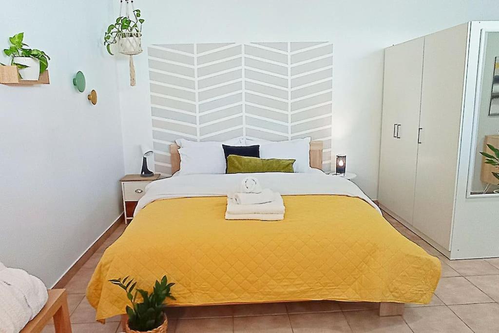 1 dormitorio con 1 cama grande con manta amarilla en Relaxing Studio Apt, 1 min to Highway, Parking, en Atenas