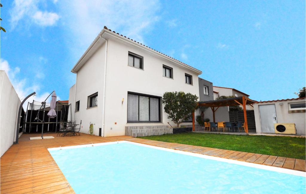 ein Haus mit einem Pool vor einem Haus in der Unterkunft Amazing Home In Torreilles With Heated Swimming Pool in Torreilles