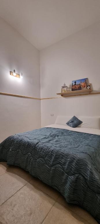 1 dormitorio con 1 cama con manta azul en B&B VIA NAPOLI LEVERANO, en Leverano