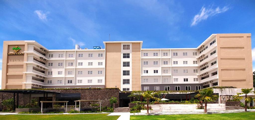 un gran edificio blanco con césped delante en Montana Premier Senggigi en Senggigi 