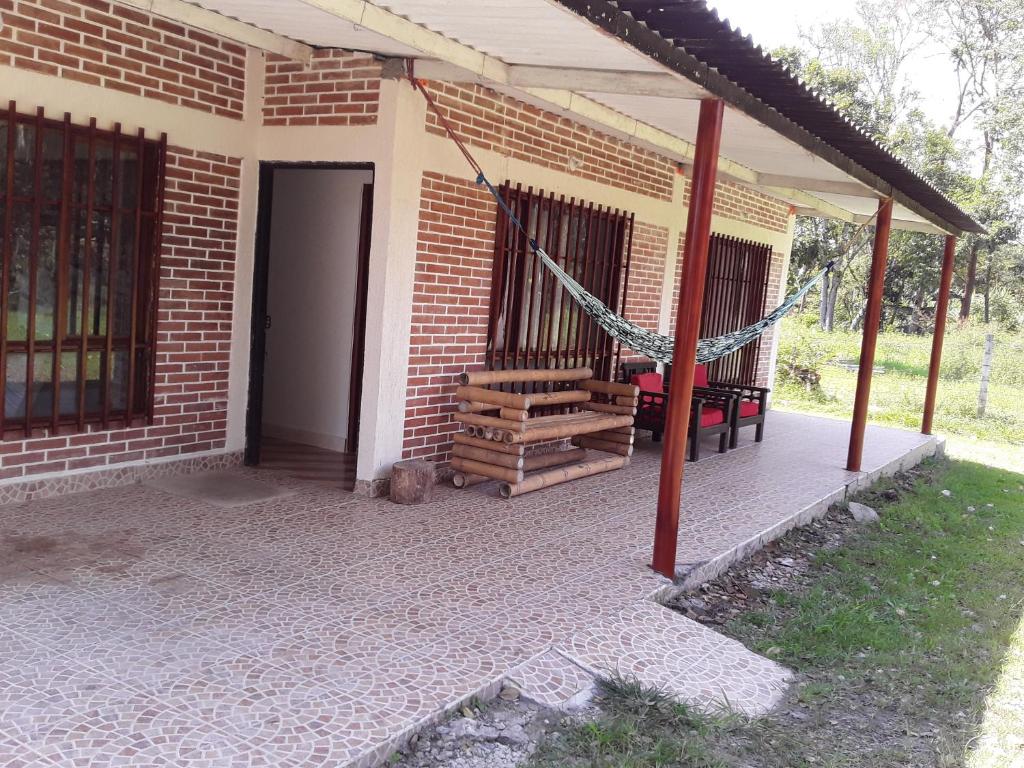 ein Haus mit einer Veranda mit einer Hängematte darauf in der Unterkunft Hospedaje villa luz in Pitalito