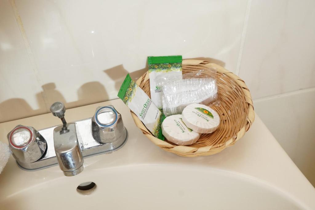 a basket of toiletries sitting on top of a sink at Hotel Palace Ejecutivo in San Pedro Sula