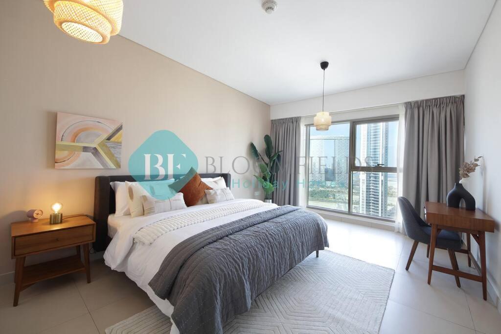 a bedroom with a bed and a desk and a window at Luxury 2 Bedroom In Reem Island in Abu Dhabi