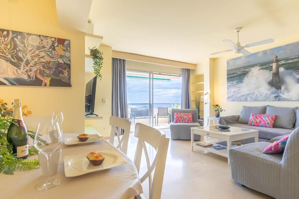 a living room with a couch and a table and chairs at Marbella Este Next Marriott and Nikki B - Happy Rentals in Marbella