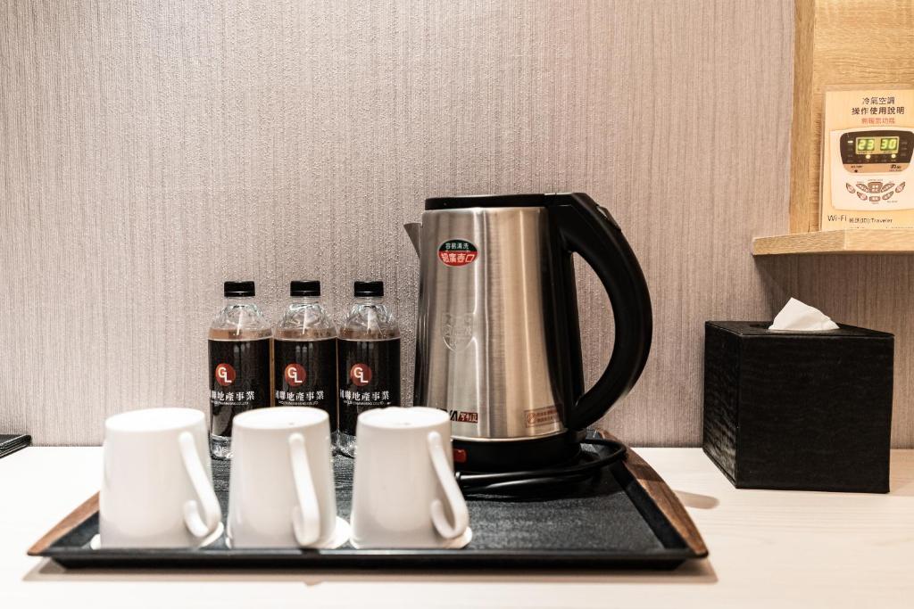 a coffee maker on a tray with bottles of water at Global Traveler Hotel in Kaohsiung