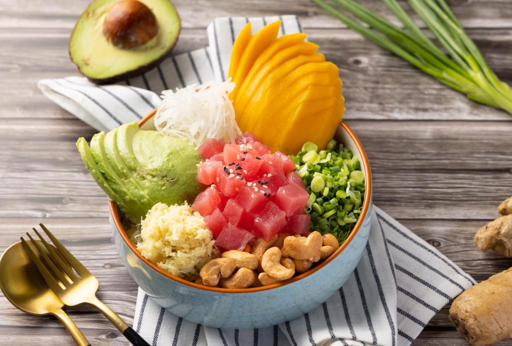a bowl of food with fruit and vegetables on a table at The Culture Samui in Bangrak Beach
