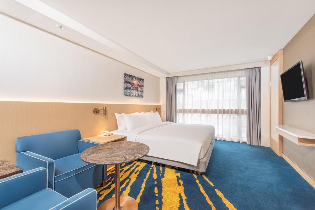 Habitación de hotel con cama, mesa y sillas en Holiday Inn Golden Mile, an IHG Hotel, en Hong Kong